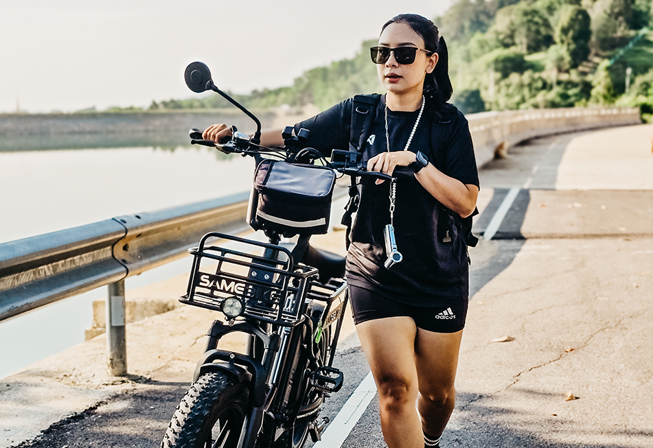 Woman walking with a Buddy Bike electric bike at Bang Wad Reservoir in Phuket