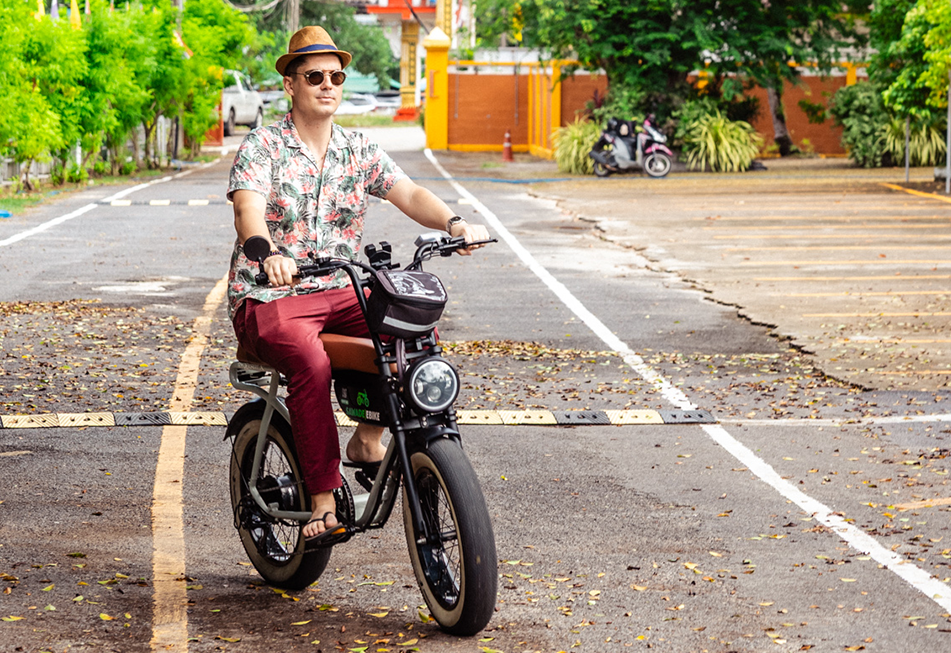 A classy young men with a hat riding a Earl Grey ebike next to Naiharn Beach, in a bouddhist temple