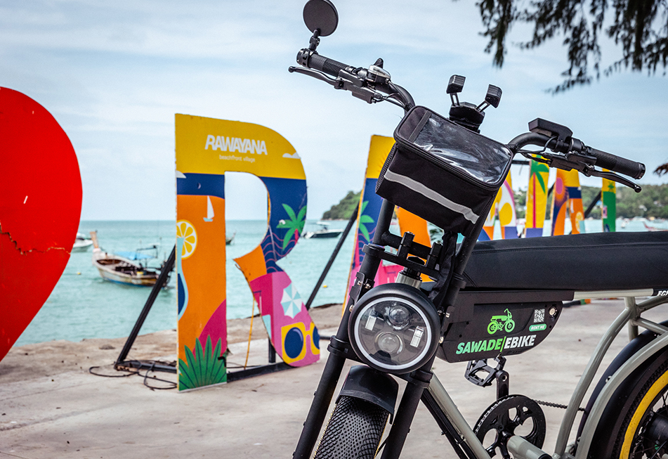 A Earl Grey ebike front of the Rawai Beach Sign